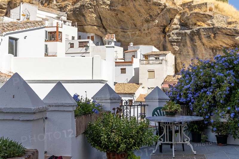 On the road to the white villages. Paths and narrow streets of a historic old town with many white houses built on and in the mountain. Setenil de las Bodegas, Cadiz, Andalusia, Spain
