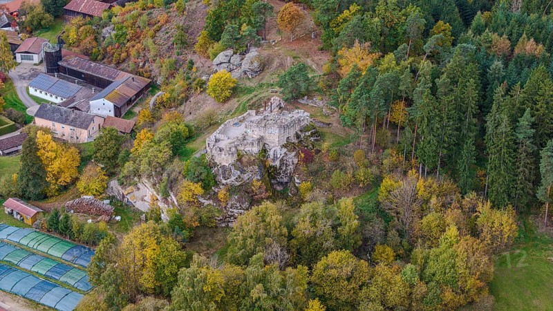 An old castle ruin stands in the middle of the autumn forest, surrounded by colorful trees of various colors. The surrounding area is quiet and shows nature over the course of the seasons. Liebenstein, Upper Palatinate