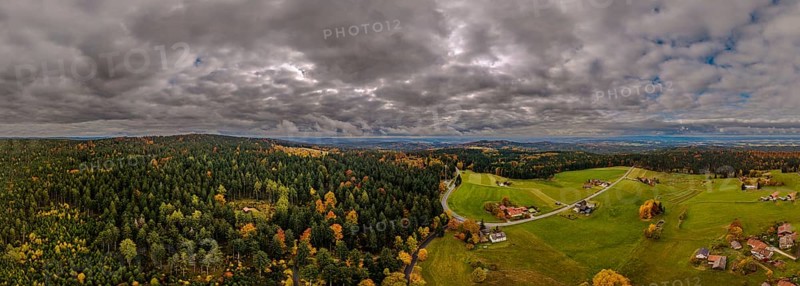 In Upper Palatinate, the autumn landscape features colorful trees and a gentle hilly landscape. Grey clouds move across the vastness of the sky. Nature presents itself in full splendor. Altglashütte, Upper Palatinate