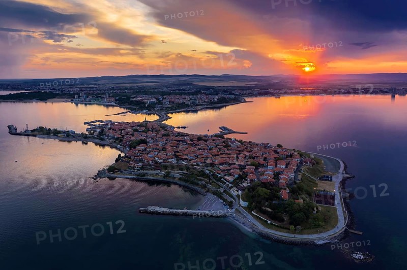 Aerial view of a peninsula at sunset with an orange sky and calm sea. Aerial view to old town of Nessebar, Bulgaria at sunset