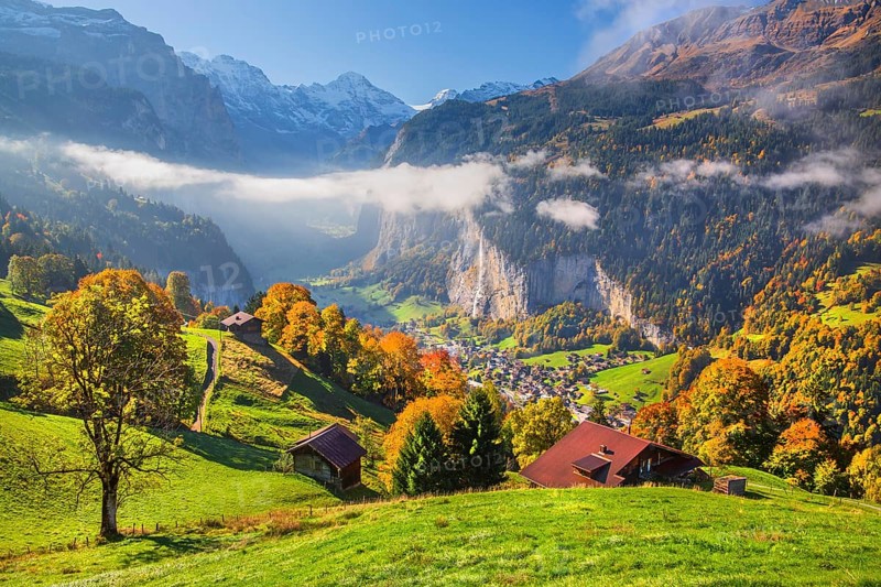 View from the village of the Lauterbrunnen Valley with Staubbach waterfall in autumn with morning fog, Wengen, Bernese Oberland, Canton of Bern, Switzerland