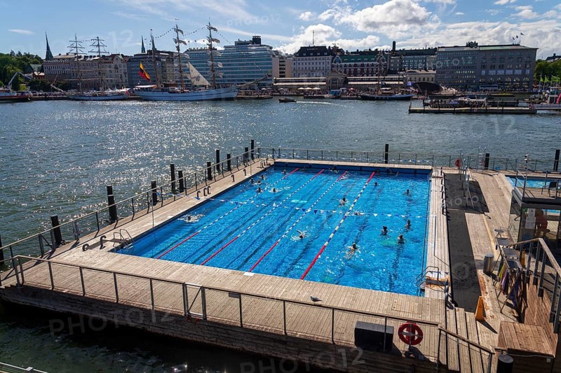 HELSINKI, FINLAND - JULY 6 2024: People enjoying public sea swimming pool and traditional sauna on sunny summer day in city center at Katajanokanlaituri on July 6, 2024 in Helsinki, Finland