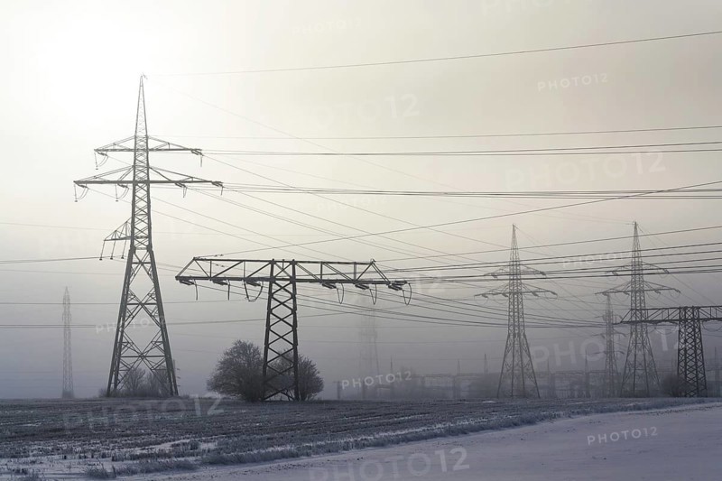 Electricity pylons from distribution power station in foggy winter freeze Prague Czech republic
