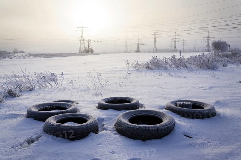 Winter tires on snow with electricity distribution plant in background Prague Czech republic