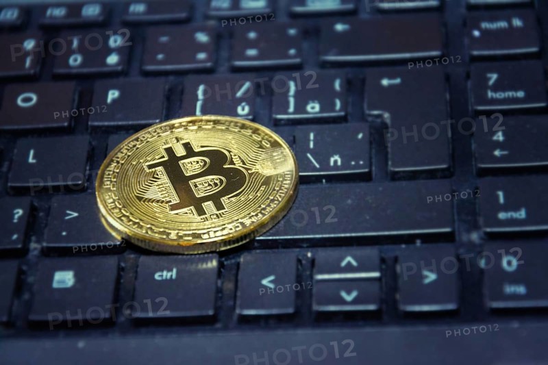 Golden bitcoin coin lying on green computer keyboard, cryptocurrency investing concept Prague Czech republic