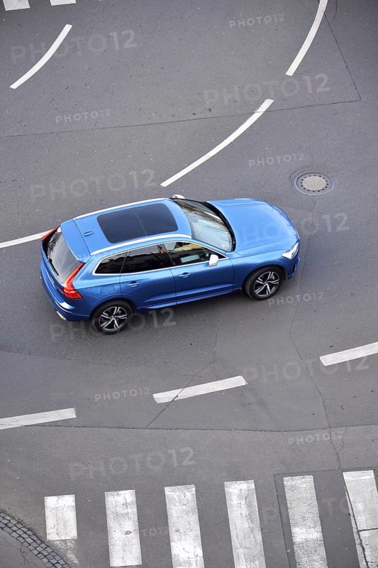 Blue unrecognizable car moving on road with broken line near pedestrian crossing, driverless autonomous technology concept, aerial birds eye view Prague Czech republic