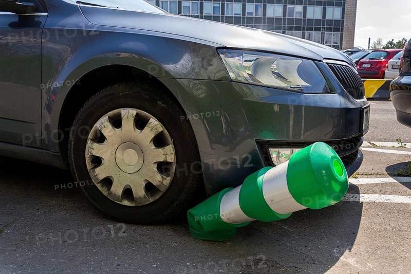 Car bending white and green safety traffic post with front bumper, wrong parking, car insurance, fine, penalty concept Prague Czech republic