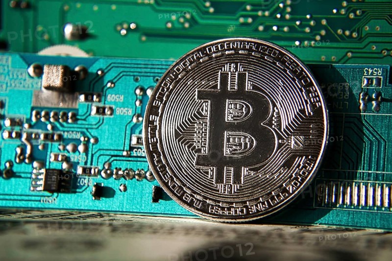 Silver bitcoin coin in front of computer motherboard, cryptocurrency mining and investing concept Prague Czech republic