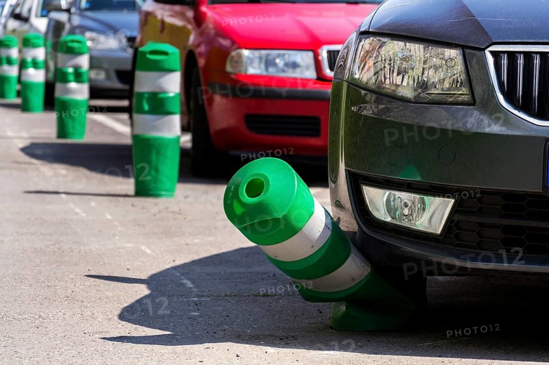 Car bending white and green safety traffic post with front bumper, wrong parking, car insurance, fine, penalty concept Prague Czech republic