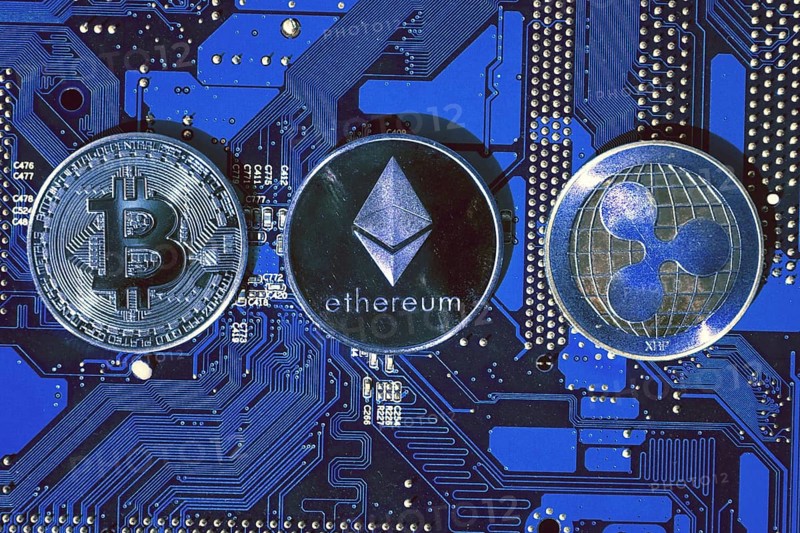 Bitcoin, Ethereum, Ripple coins on computer motherboard, cryptocurrency investing concept Prague, Czech republic