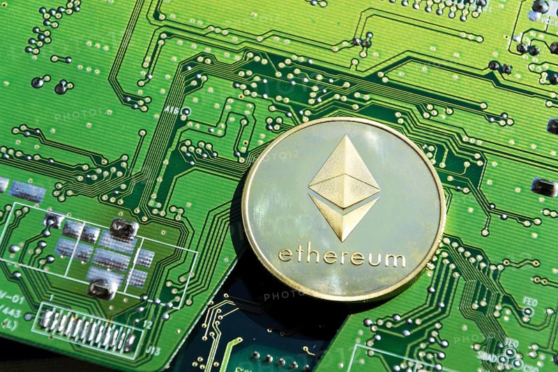 Golden Ethereum coin lying on computer motherboard, cryptocurrency investing, blockchain technology concept Prague, Czech republic