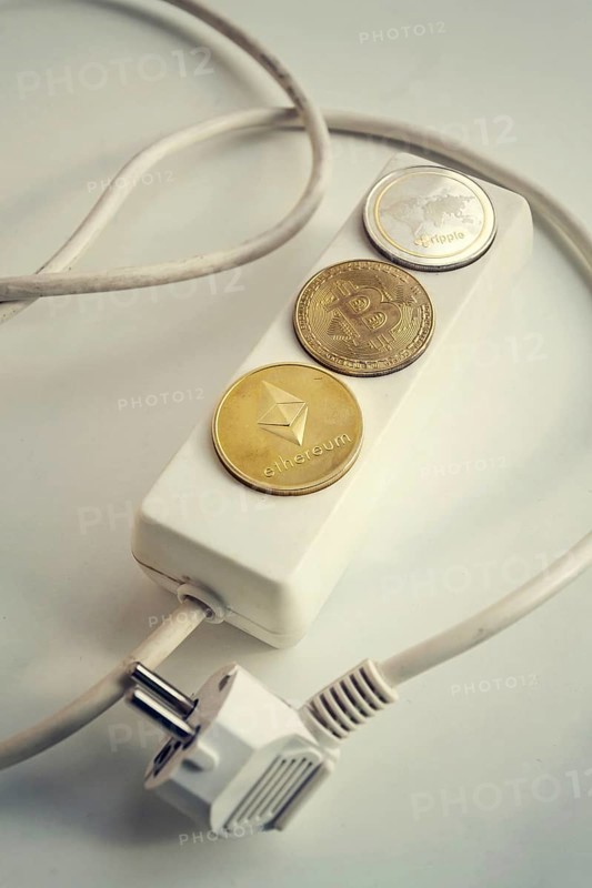 Bitcoin, Ethereum and Ripple coins lying on power strip extension cord with 3 sockets, largest cryptocurrencies by market capitalization, cryptocurrency investing, energy consumption and footprint concept Prague Czech republic