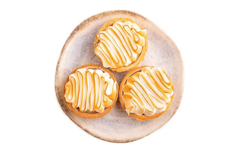 French lemon tart with meringue isolated on white background, top view, flat lay, close up