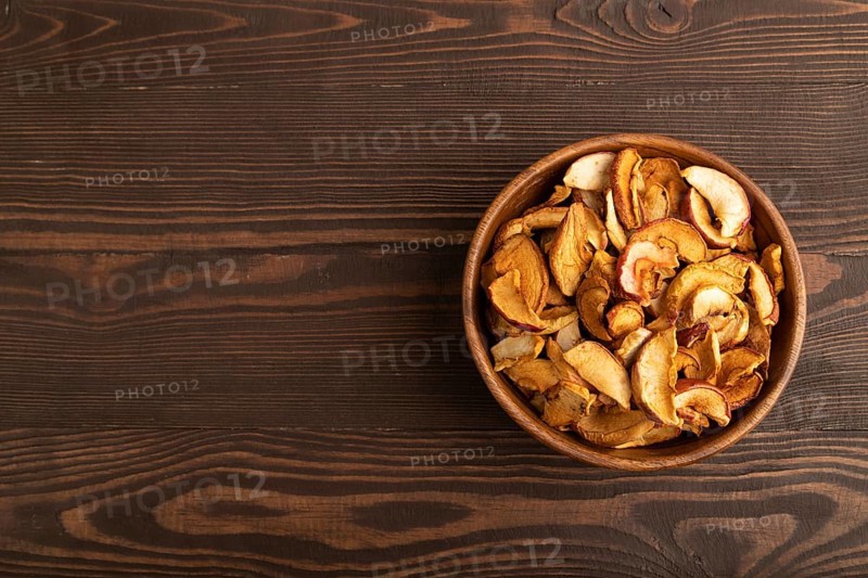 Dried Apples in wooden bowl on brown wooden background. Top view, copy space, flat lay. healthy food, minimalism. sweet
