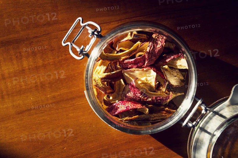 Dried apples and pears in open glass jar lying on wooden table, organic fruit food, healthy lifestyle Prague Czech republic