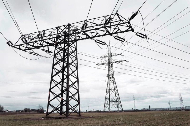 Electricity pylons conducting current from distribution power station, solar renewable energy and grid stability concept, copy space dramatic clouds Prague Czech republic