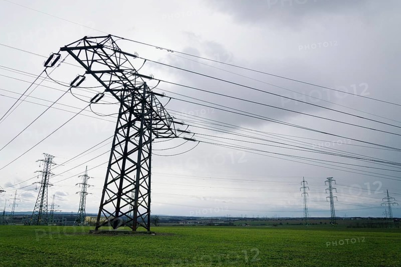 Electricity pylons conducting current from distribution power station with dramatic cloudy sky copy space background Prague Czech republic