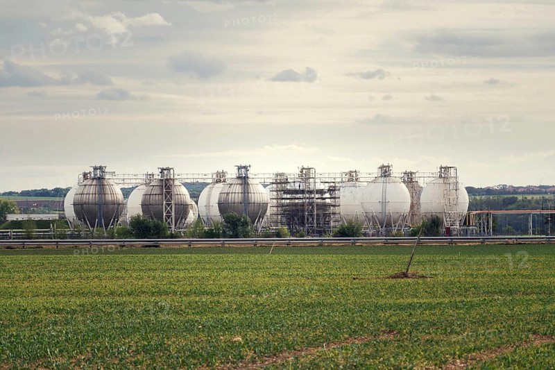 Liquid and fluid gas holder storage, sphere shape container tanks, green field in foreground Prague Czech republic