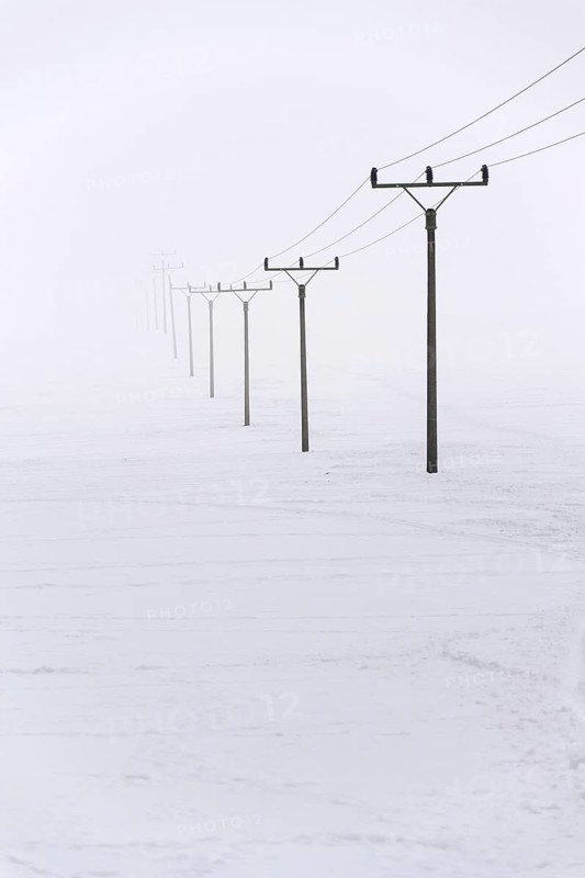 Electricity pylons from distribution power station disappearing in deep fog, winter freezing weather concept Prague Czech republic