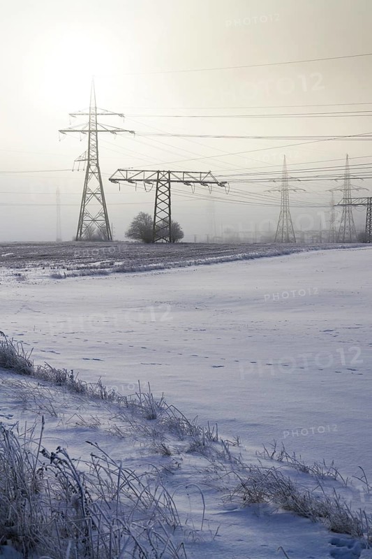 Electricity pylons from distribution power station in foggy winter freeze Prague Czech republic