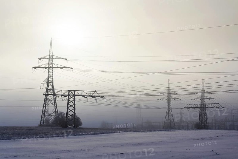 Electricity pylons from distribution power station in foggy winter freeze Prague Czech republic