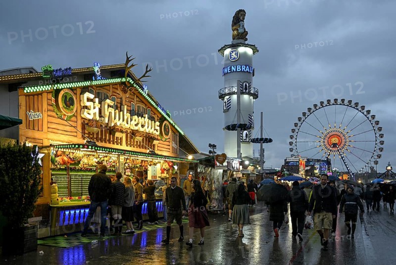 Oktoberfest visitors with umbrellas, rainy meadows, Löwenbräuturm, Ferris wheel, Munich, Bavaria, Germany