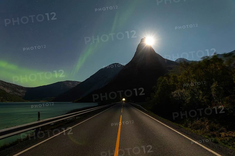 National mountain of Norway, Stetind in the Nordland under auroras and with a full moon shining behind the summit