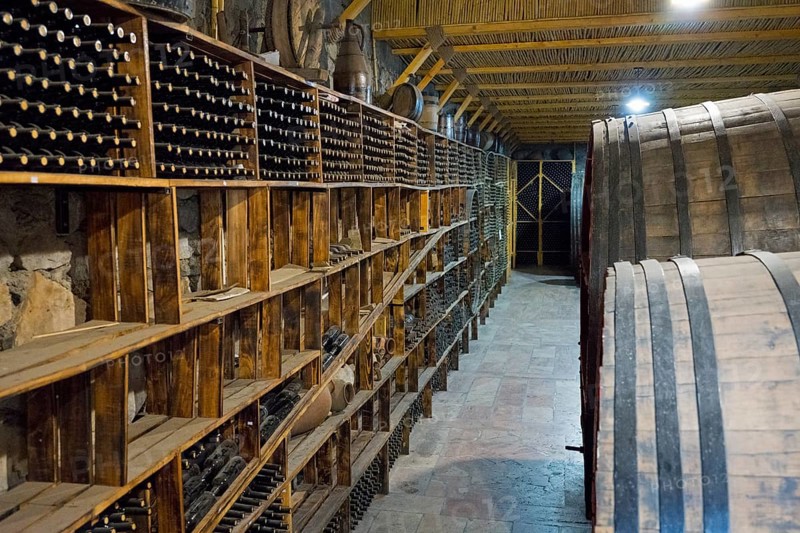 A wine cellar with wooden shelves and large barrels conveys a rustic atmosphere, Hin Areni Winery, Vayots Dzor Province, Wajoz Dzor, Armenia, Caucasus