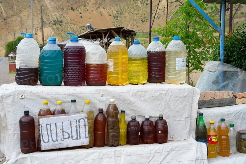 Various juices in plastic bottles at a rural market with mountain scenery, selling wine in Areni village, Vayots Dzor province, Vayots Dzor, Armenia, Caucasus