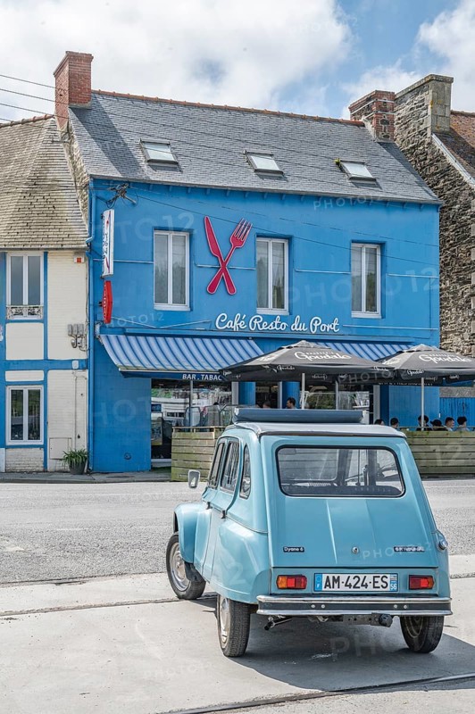 Parked sky blue Citroen 2CV with roll top in front of Café Resto du Port Le Surcouf, a popular simple restaurant in the Port du Legue industrial port, Saint-Brieuc, department of Cotes-d'Armor, Brittany region, France