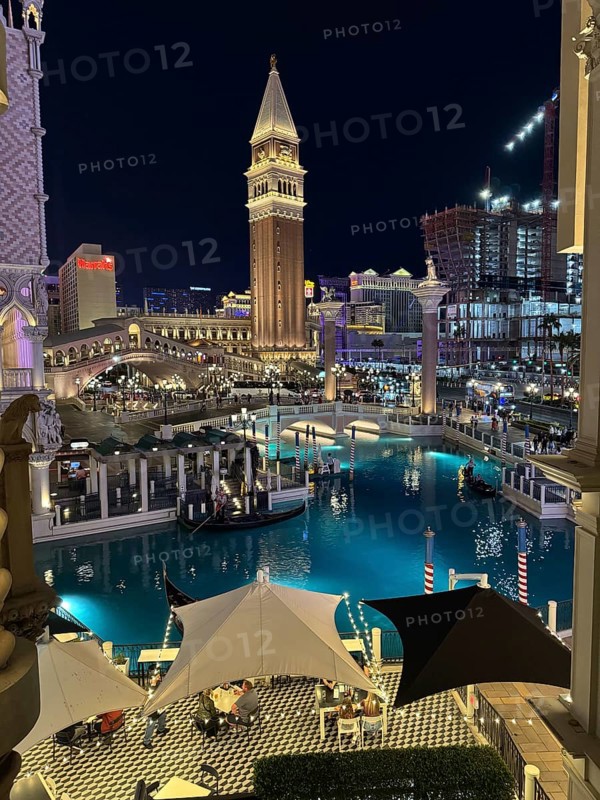 Since the legalization of gambling in the 1930s, Las Vegas has developed as a tourist center of international importance. Where simple casinos initially settled, Las Vegas is now characterized by luxurious hotel complexes with large casinos and leisure facilities, illuminated canal scene at night with distinctive architecture and water tower, Las Vegas, Nevada, USA