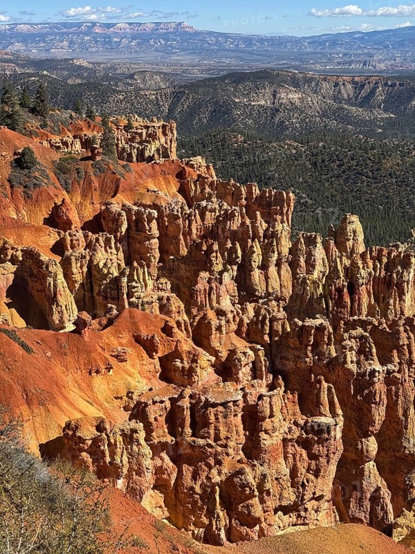 Impressive red rock landscape with sweeping views over layered, smoky rocks, Bryce Canyon National Park is located in southwestern Utah in the United States, view of impressive rocks and red formations in the canyon with mountain scenery in the background, Tropic, Utah, USA