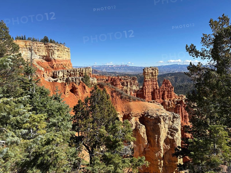 Red cliffs and thick forests stretch to the horizon under deep blue skies, Bryce Canyon National Park is located in southwestern Utah in the United States, sweeping view of rock formations and mountains in the background, Tropic, Utah, USA