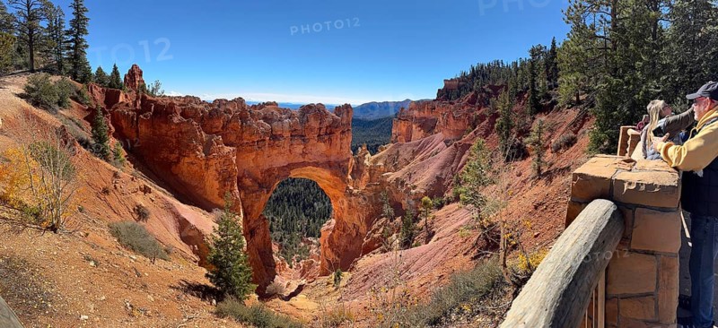 Visitors look at a majestic rock arch from a vantage point in the canyon, Bryce Canyon National Park is located in southwestern Utah in the United States, tourists photograph a large rock arch in nature, Tropic, Utah, USA