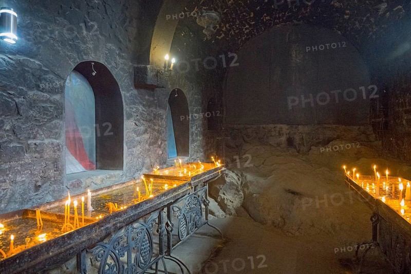 The room with candlelight creates a quiet, subdued atmosphere with stone walls, Khor Virap monastery, deep dungeon, Ararat province, Armenia