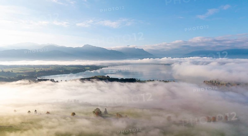 Morning fog covers a vast landscape with Lake Forggensee, near Roßhaupten, Ostallgäu, Allgäu, Swabia, Bavaria, Germany