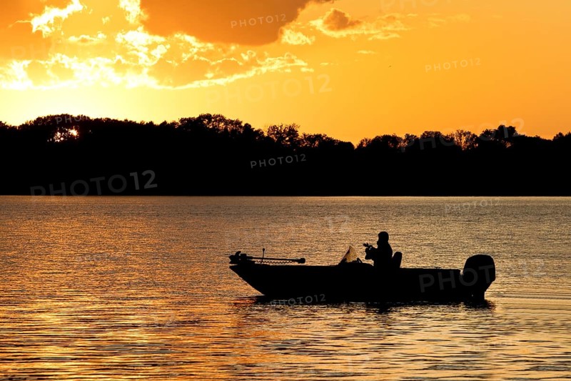 A boat on Lake Gudelack at sunset, Lindow (Mark), Stechlin-Ruppiner Land nature park Park, Brandenburg, Germany