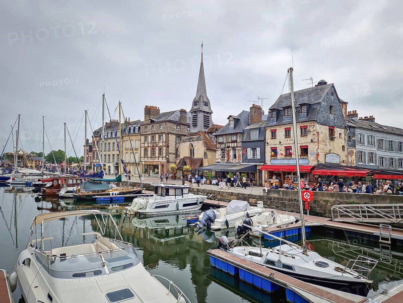 Honfleur, Normandy, France, May 30, 2025: Honfleur Vieux Bassin harbor with boats and yachts moored in the still water, and a row of colorful buildings in the background, Honfleur, Normandy, France
