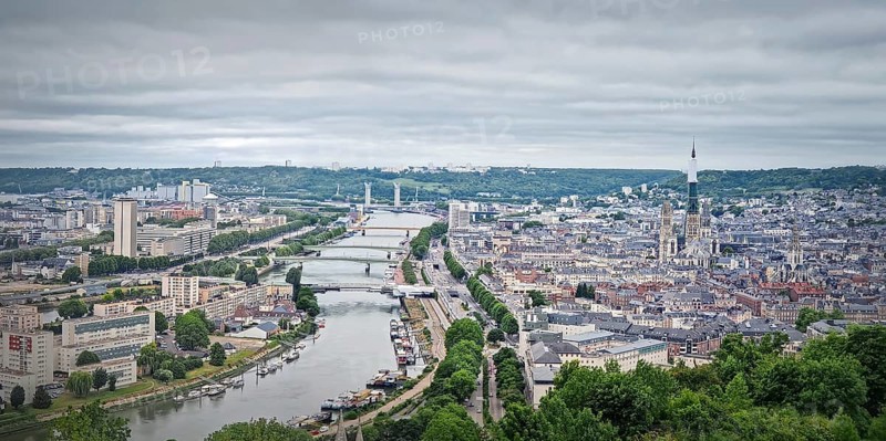 Panoramic view of the Rouen city in France, with the winding Seine river and numerous bridges. Elevated cityscape view from Sainte-Catherine hill with the towering cathedral Notre-Dame de l'Assomption, Rouen, France