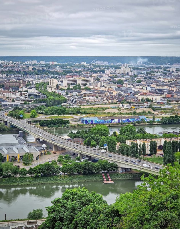Rouen, France, May 29, 2025: Elevated view of the french city of Rouen, from the hill Sainte-Catherine, under a cloudy sky, with Seine river in the foreground, Rouen, France