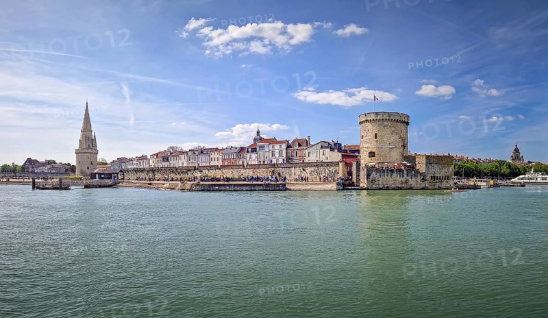 The entrance to the Vieux Port of La Rochelle, France. Panoramic view of all the medieval landmarks guarding the marina, the chain and the lantern towers, La Rochelle, France