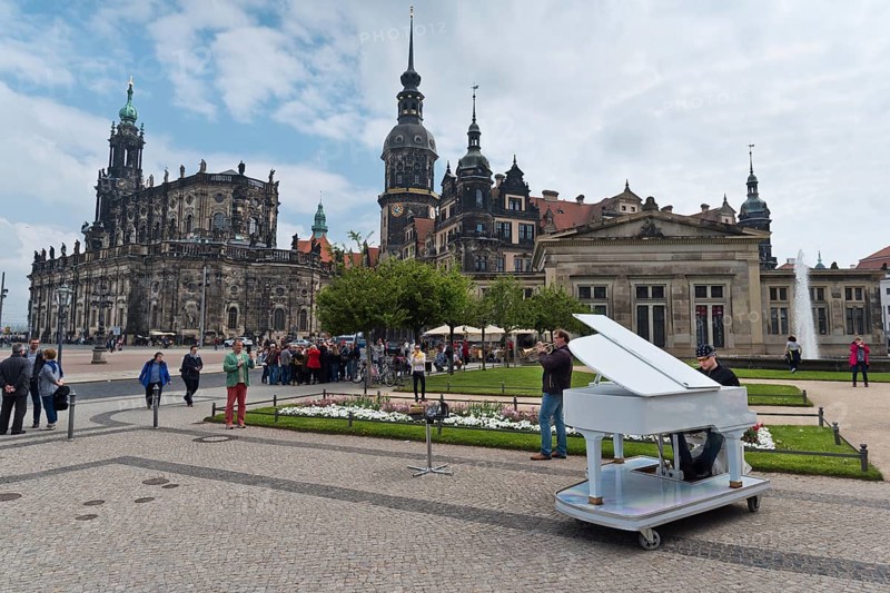 Dresden, Gerrmany- May 6, 2017: Musicians are playing on the sqare in the background Cathedral of the Holy Trinity and Dresden Castle