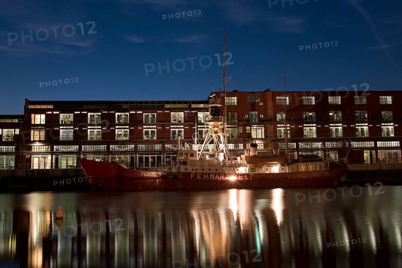 LUBECK, GERMANY - AUGUST 3, 2016: Ship in harbor during twilight. Lubeck is the 2nd largest city in Schleswig-Holstein region. Its old town is on a UNESCO World Heritage Site