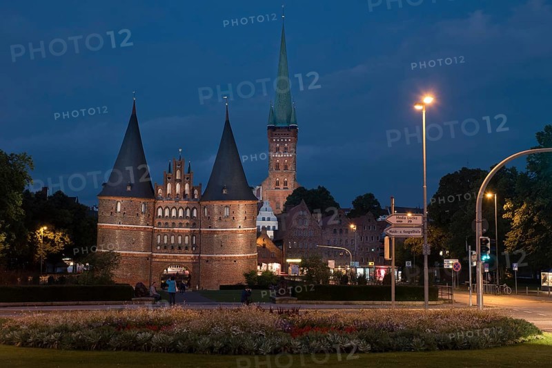 LUBECK, GERMANY - AUGUST 3, 2016: Holstentor Gate and st Jakob church during twilight. Lubeck is the 2nd largest city in Schleswig-Holstein region. Its old town is on a UNESCO World Heritage Site