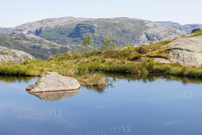 A mountain lake in the alpine tundra landscape of the Scandinavian Mountains near the Preikestolen hiking trail in Rogaland. Seen on a sunny, clear summer day. Vestlandet, Western Norway
