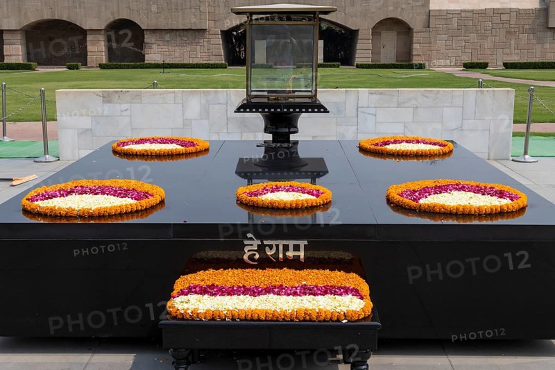 Black marble memorial at Raj Ghat in Delhi, dedicated to Mahatma Gandhi, Mohandas Karamchand Gandhi, the leader of the successful, nonviolent campaign for the independence of India. Location of the monument, with the eternal flame on it, marks the spot on the bank of Yamuna River, where Gandhi was cremated after his assassination. National Capital Territory of Delhi, India