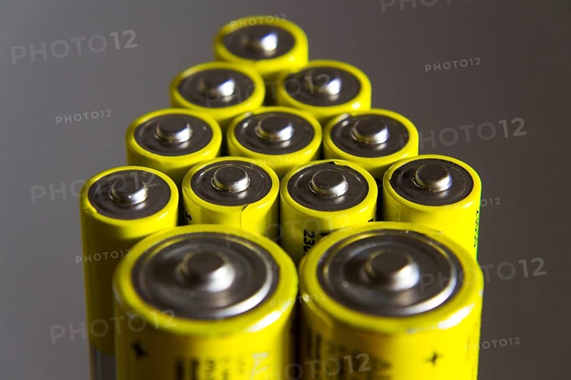 Stack of yellow AA batteries close up, electricity storage concept