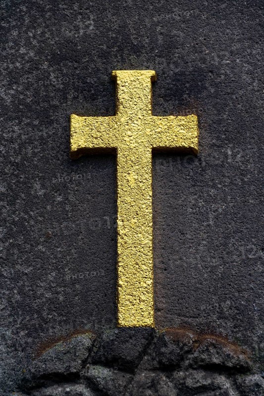 Golden Christian cross on stone background, tomb in the cemetery, life and death concept
