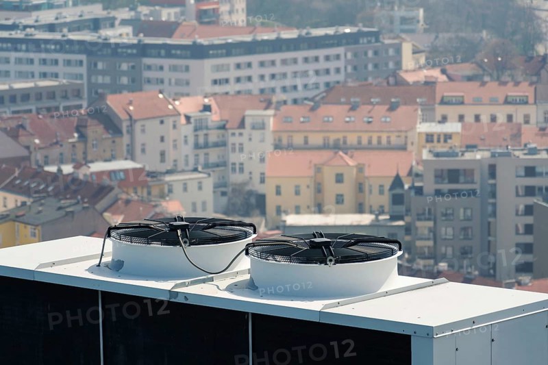 Air conditioning ventilators on roof with houses in background Prague Czech republic