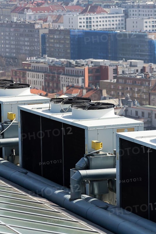 Air conditioning ventilators on roof with houses in background Prague Czech republic